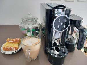 a coffee maker sitting on a counter with a plate of food at Luna place in Eilat