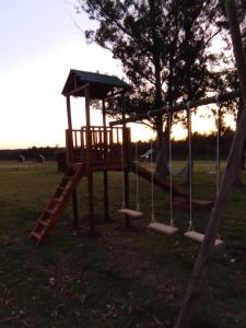 a playground with a slide and a tree at Centro Los Alamos in Maldonado