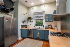 a kitchen with blue cabinets and a stainless steel refrigerator at Town Square Motel in Orange