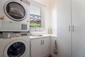 a kitchen with a washing machine and a sink at Town Square Motel in Orange