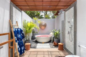 a bathroom with a tub and plants in it at Suga Estate - Rice Field View Villas in Ubud