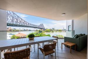 a balcony with a table and chairs and a view of a bridge at Story Bridge view apartment with parking and pool in Brisbane