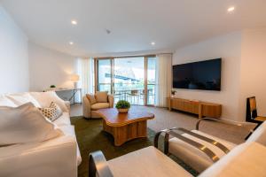 een woonkamer met een bank en een tv bij Story Bridge view apartment with parking and pool in Brisbane