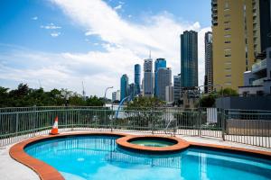 a swimming pool with a city skyline in the background at Story Bridge view apartment with parking and pool in Brisbane