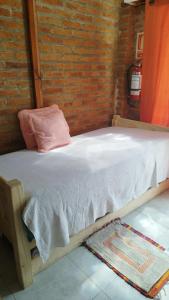 a wooden bed in a room with a brick wall at Dublin in Rocha