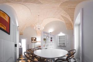 ein Esszimmer mit einem weißen Tisch und Stühlen in der Unterkunft Arabesque Luxury Apartment - Roof Garden in Taranto