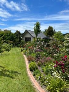 Tasman Village Cottage في Tasman: حديقة بها زهور أمام المنزل