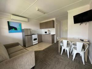 a living room with a couch and a table with chairs at Shelly Beach Holiday Park in The Entrance