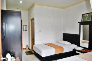 Pokój hotelowy z łóżkiem i lustrem w obiekcie Wis-Inn Wisma Industri w mieście Tagalbato