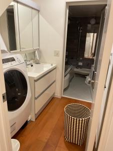 een badkamer met een wasmachine en een wastafel bij Skytree House In Tokyo in Tokyo