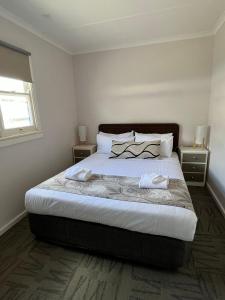 una camera da letto con un grande letto con due comodini di Shelly Beach Holiday Park a The Entrance
