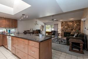 an open kitchen and living room with a stone wall at Bright & spacious home with pool in Albuquerque