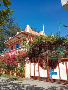 Una casa con una valla con flores. en Mommy Linda Beach Resort, en Cabangan