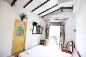 a room with a bed and a yellow door at Sinharaja River Face holiday in Nelluwa +11 photos