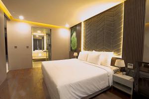 um quarto com uma grande cama branca e uma casa de banho em Elite Hotel em Ha Long
