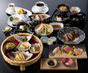 ein Tisch mit vielen Teller Essen drauf in der Unterkunft Hotel Morinokaze Hakone Sengokuhara in Hakone
