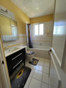y baño con lavabo, bañera y aseo. en STUNNING 2 Bedroom House at Point Village Negril en Negril