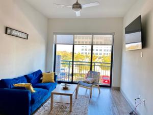 a living room with a blue couch and a table at The Baobab - Addison in Dallas