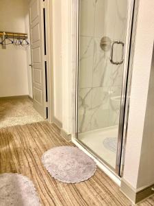 a bathroom with a shower and two rugs at The Baobab - Addison in Dallas