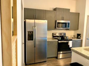 a kitchen with a stainless steel refrigerator and microwave at The Baobab - Addison in Dallas
