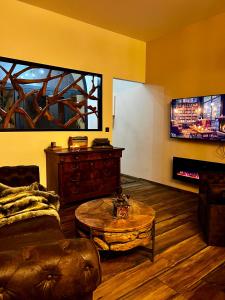 Una sala de estar con un sofá, una mesa y un televisor. en Le secret d’Adam, en Rouen 23 fotos más