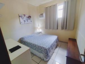 a small bedroom with a bed and a window at Casa Julieta in Resende
