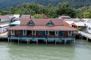 ein Haus auf einem Pier auf dem Wasser in der Unterkunft Mangrove House Lanta Old Town in Ko Lanta