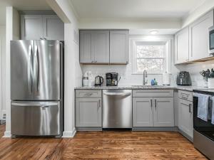 a kitchen with a stainless steel refrigerator and white cabinets at 4 Bedroom Plaza Charmer Pet Friendly in Kansas City
