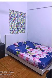 Una cama con un edredón azul con flores. en Homestay Budget Ampang for Malay en Ampang