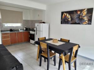 a kitchen with a table and chairs and a white refrigerator at Dreams in Río Gallegos