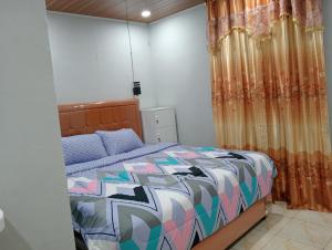 - une chambre avec un lit et un rideau dans l'établissement Vulkaan Homestay, à Berastagi