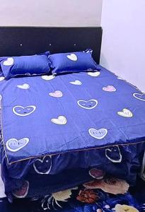 a bed with a blue comforter with hearts on it at Homestay Budget Ampang for Malay in Ampang