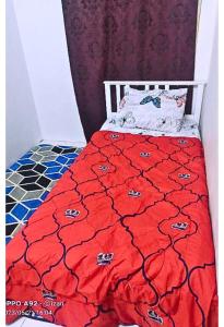 a bedroom with a bed with a red comforter at Homestay Budget Ampang for Malay in Ampang
