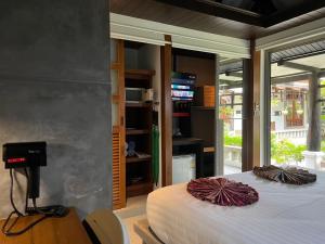 a bedroom with two beds and a table and some windows at Bangtao Beach Chalet Resort in Bang Tao Beach