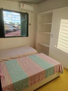 um quarto com 2 camas, uma janela e prateleiras em Privê Sol e Mar em Cabo de Santo Agostinho