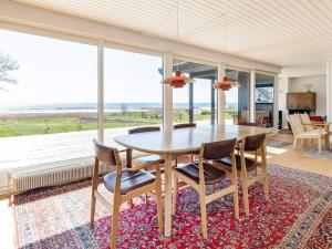 jadalnia ze stołem i krzesłami oraz dużym oknem w obiekcie Holiday home Assens IX w mieście Assens