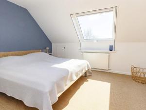 1 dormitorio con cama blanca y ventana en Holiday home Assens IX, en Assens
