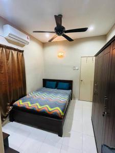 una camera da letto con un letto e un ventilatore a soffitto di Semi -D Homestay Seremban 2 a Seremban