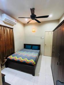 a bedroom with a bed and a ceiling fan at Semi -D Homestay Seremban 2 in Seremban