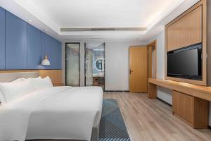 a hotel room with a bed and a flat screen tv at Holiday Inn Express Huangshi Cihu Lake, an IHG Hotel in Huangshi