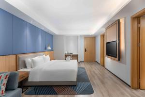 um quarto de hotel com uma cama e uma televisão em Holiday Inn Express Huangshi Cihu Lake, an IHG Hotel em Huangshi