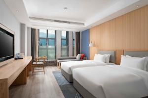 pokój hotelowy z 2 łóżkami i telewizorem z płaskim ekranem w obiekcie Holiday Inn Express Huangshi Cihu Lake, an IHG Hotel w mieście Huangshi
