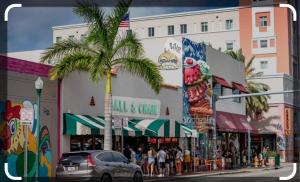 a busy city street with a palm tree and a crowd of people at Beds & Sheets Little Havana in Miami
