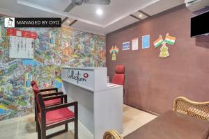 ハイデラバードにあるSuper Collection O Townvilla Guest House near Begumpet Metro Stationの壁画のある部屋(テーブル、椅子付)