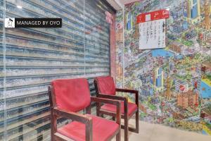 two red chairs in front of a mural at Super Collection O Townvilla Guest House near Begumpet Metro Station in Hyderabad