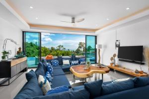 uma sala de estar com um sofá azul e uma mesa em Nelumbo Villa - Lamai Seaview - 4 bedroom em Nathon Bay