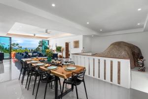 uma sala de jantar com uma mesa longa e cadeiras em Nelumbo Villa - Lamai Seaview - 4 bedroom em Nathon Bay