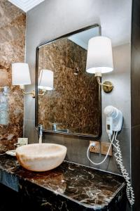 W łazience znajduje się umywalka i lustro. w obiekcie Puri Raja Hotel w mieście Legian