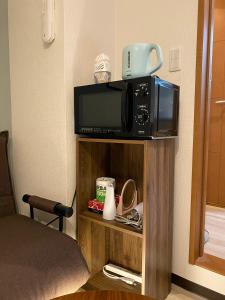 a microwave on a shelf in a hotel room at マルチステイ大阪京橋22 in Osaka