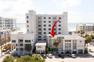 a large white building with a red arrow on it at Coastal Sea Side Townhome in Clearwater Beach
